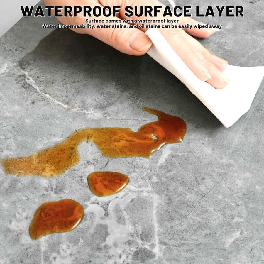 Wiping a surface spill from a gray marble-look tile