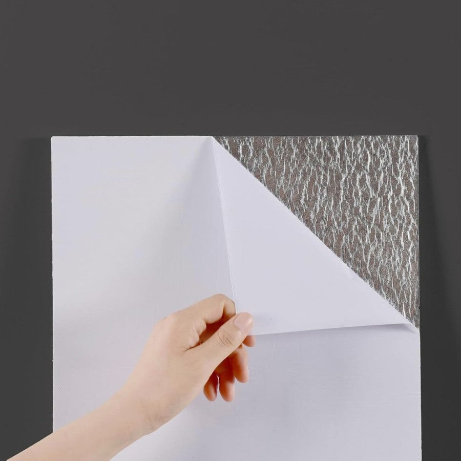Peeling the protective backing from a wall tile