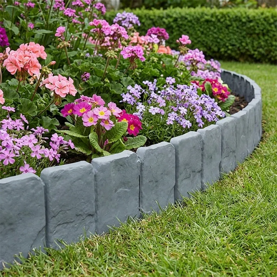 Curved stone-effect border separating flowers and lawn